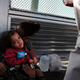 A Honduran child and her mother, fleeing poverty and violence in their home country, waits along the border bridge after being denied entry from Mexico into the U.S. on June 25, 2018 in Brownsville, Texas